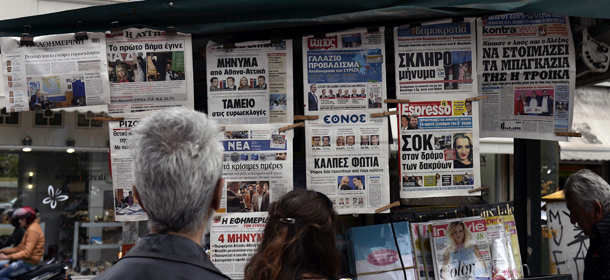 People read newspaper's headlines featuring the local elections first round results on May 19, 2014 in central Athens. A first round of local elections in Greece on May 18 showed no clear victor hours after polls closed, with the anti-austerity leftist Syriza party battling for Athens and the coalition government's candidates holding on outside the capital. AFP PHOTO/ LOUISA GOULIAMAKI (Photo credit should read LOUISA GOULIAMAKI/AFP/Getty Images)