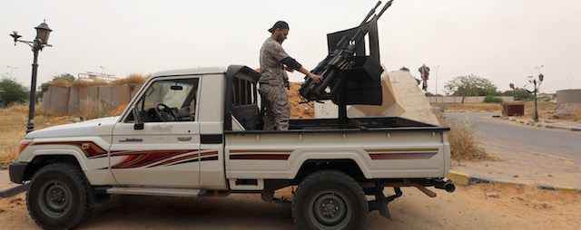 Former rebel fighters who are now intergrated into the Libyan army and form the Diraa al-Gharbiya brigade, are seen with their weapons guarding the western entrance of Tripoli on May 19, 2014. A dramatic spike in lawlessness in Libya's two largest cities has edged the country closer to civil war between heavily armed rival militias, stirring concern abroad and on oil markets. AFP PHOTO/MAHMUD TURKIA (Photo credit should read MAHMUD TURKIA/AFP/Getty Images)