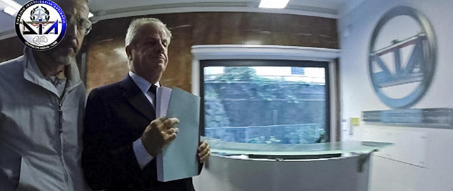 This image made from a video made available by the Italian anti-mafia DIA unit shows Claudio Scajola, right, a former minister in several of Silvio Berlusconi's center-right governments, as he is taken to the DIA headquarters after he was arrested Thursday, May 8, 2014, in a luxury Rome hotel, for allegedly helping a prominent businessman convicted of Mafia association flee abroad. Claudio Scajola was accused of helping political ally Amedeo Matacena flee to Dubai last summer to avoid a five-year jail sentence and of then trying to arrange asylum for him and relatives in Lebanon using government contacts. (AP Photo/DIA, ho)