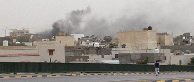 In this image made from video provided by the Libyan national army via AP Television, smoke rises over the parliament area after troops of Gen. Khalifa Hifter targeted Islamist lawmakers and officials at the parliament in Tripoli, Libya, Sunday, May 18, 2014. Forces loyal to a rogue Libyan general attacked the country's parliament Sunday, expanding his eastern offensive against Islamists into the heart of the country's capital. (AP Photo/Libyan national army)