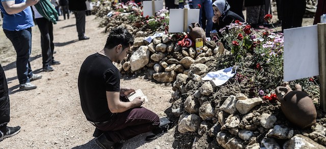 A man prays in front of the grave of a relative at the cemetery where some of the 301 people killed after an explosion and fire in a coal mine were buried, on May 18, 2014, at Soma in Manisa. Turkey on May 17, 2014 declared rescue operations over following this week's devastating coalmine blast after retrieving the bodies of two last trapped miners, bringing the final death toll to 301. AFP PHOTO / BULENT KILIC (Photo credit should read BULENT KILIC/AFP/Getty Images)