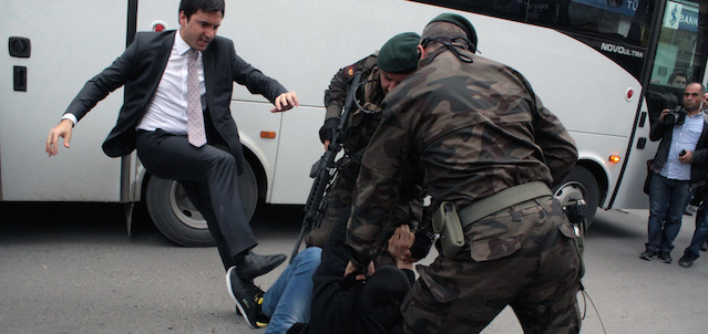 In this photo taken Wednesday, May 14, 2014 a person identified by Turkish media as Yusuf Yerkel, advisor to Turkish Prime Minister Recep Tayyip Erdogan, kicks a protester already held by special forces police members during Erdogan's visiting Soma, Turkey. Erdogan was visiting the western Turkish mining town of Soma after Turkey's worst mining accident . AP Photo/Depo Photos) TURKEY OUT