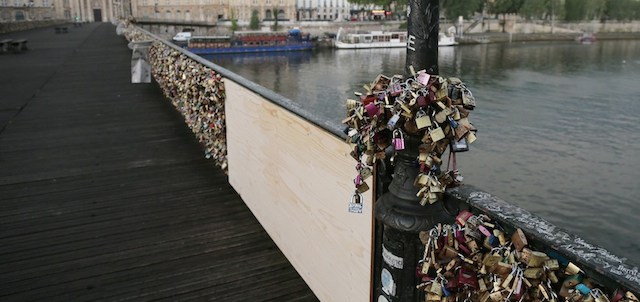 A photo taken on June 9, 2014 shows 'love padlocks' attached to a fence of the Pont des Arts bridge over the Seine river in Paris. Thousands of 'locks of love' attached to the footbridge caused part of the railing to collapse, forcing an evacuation on June 8. Thousands of lovers from across the world visit the Pont des Arts every year and seal their love by attaching a lock carrying their names to its railing and throwing the key in the Seine. The phenomenon has become something of a headache for officials in the City of Light, who would prefer something that poses fewer problems of security and aesthetics. AFP PHOTO /JACQUES DEMARTHON (Photo credit should read JACQUES DEMARTHON/AFP/Getty Images)