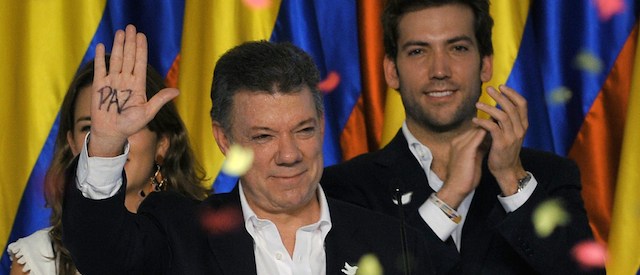 Colombian President and presidential candidate Juan Manuel Santos shows the palm of his hand reading "Peace" as he celebrates after knowing the results of the runoff presidential election on June 15, 2014, in Bogota. Santos was re-elected with 50.90 percent of the vote, compared with 45.04 percent for the more conservative Oscar Ivan Zuluaga, with 99.37 percent of votes tallied. AFP PHOTO/Guillermo LEGARIA (Photo credit should read GUILLERMO LEGARIA/AFP/Getty Images)