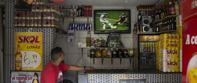SAO PAULO, BRAZIL - JUNE 21: A television shows a World Cup match in a bar in the poor neighbourhood of Itaquera, adjacent to the 'Arena de Sao Paulo' stadium, on June 21, 2014 in Sao Paulo, Brazil. The Arena de Sao Paulo, which is reported to have cost in excess of 200 million GBP, hosted the opening match of the 2014 FIFA World Cup and has a capacity of over 61,000. The total cost borne by Brazil for staging the 2014 World Cup is estimated to be 6.5 billion GBP, which critics have argued would have better spent on the millions of Brazilians living in poverty. (Photo by Oli Scarff/Getty Images)