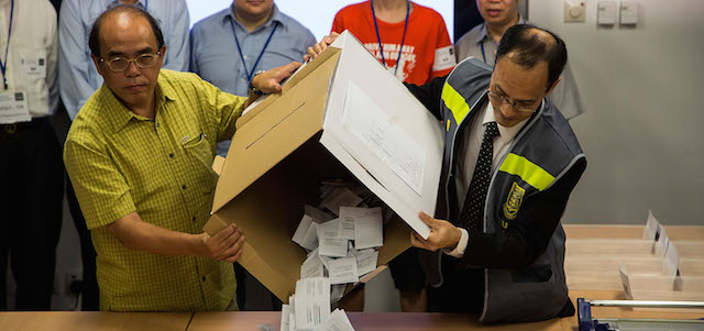 HONG KONG - JUNE 29: Ballot counting officers dump ballos on a table after the ballot boxes for were opened for a referendum on democratic reform at a counting center on June 29, 2014 in Hong Kong. The referendum was undertaken by Occupy Central and HKUPOP and more than 750,000 cast ballots. More people are expected to vote June 29, as it is Sunday and the last day of polling. (Photo by Lam Yik Fei/Getty Images)