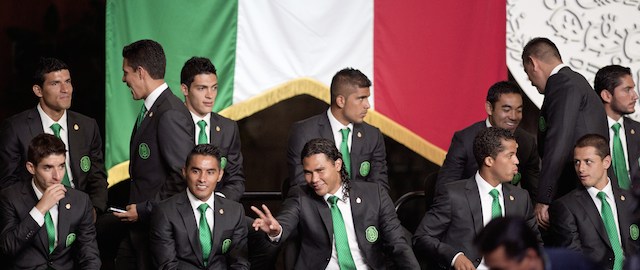 Mexico's national football team forward Carlos Pena (C) among teammates flashes a "V" during a ceremony to receive the National Flag from Mexican President Enrique Pena Nieto at the National Palace in Mexico City, on May 27, 2014. AFP PHOTO/ Yuri CORTEZ (Photo credit should read YURI CORTEZ/AFP/Getty Images)