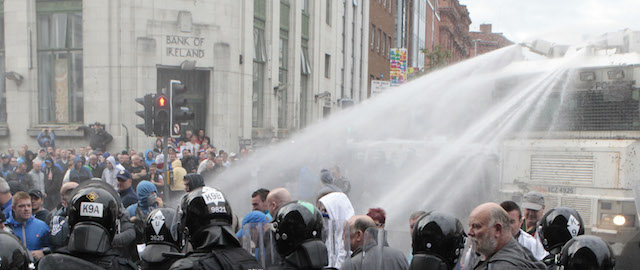 Police use a water cannon on Loyalist protesters clashing with riot police in the centre of Belfast, Northern Ireland, Friday, Aug. 9, 2013. A number of people, including police officers, have been injured during trouble in Belfast city centre linked to a republican anti-internment parade. Loyalist protesters attacked the police as they waited for the republican parade to arrive. (AP Photo/Peter Morrison)
