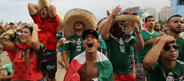 In this Friday, June 13, 2014 photo, Mexico soccer fan Jose Reyna, center, reacts as he watches his team's World Cup match with Cameroon inside the FIFA Fan Fest area on Copacabana beach in Rio de Janeiro, Brazil. Mexico won 1-0. (AP Photo/Leo Correa)