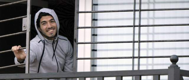 Uruguay's soccer player Luis Suarez opens his window to greet fans from his home on the outskirts of Montevideo, Uruguay, Friday, June 27, 2014. Suarez returned to Montevideo early Friday, arriving too late to see the hundreds of Uruguay fans who had gathered the previous night to give him a hero's welcome despite his World Cup banishment. (AP Photo/Matilde Campodonico)