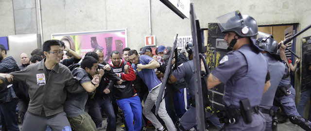 Subway train operators, along with some activists, clash with police at the Ana Rosa metro station on the second day of their metro strike in Sao Paulo, Brazil, Friday, June 6, 2014. The workers clashed with police as they tried to block other operators from breaking the strike. Overland commuter train operators went on strike Thursday, putting at risk the only means that most soccer fans will have to reach Itaquerao stadium ahead of next week's World Cup. (AP Photo/Nelson Antoine)