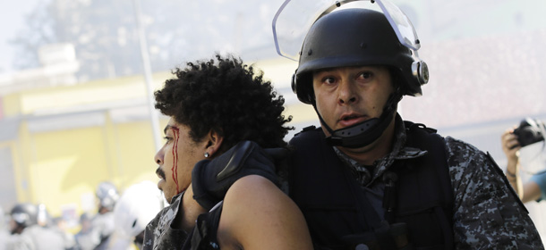 A protester is detained by police during a demonstration demanding better public services and protesting the money spent on the World Cup in Sao Paulo, Brazil, Thursday, June 12, 2014. Brazilian police clashed with anti-World Cup protesters trying to block part of the main highway leading to the stadium that hosts the opening match of the tournament. (AP Photo/Nelson Antoine)