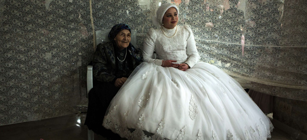 Jewish ultra-orthodox bride Rivka Hannah (Hofman) sits next to her groom's grandmother during the Mitzvah Tans dance ritual following her wedding in an ultra-orthodox neighborhood of Jerusalem on February 18, 2014. During the Mitzvah Tans dance ritual the bride will dance with members of the community, family and with her groom at the end of the wedding ceremony. AFP PHOTO/MENAHEM KAHANA (Photo credit should read MENAHEM KAHANA/AFP/Getty Images)