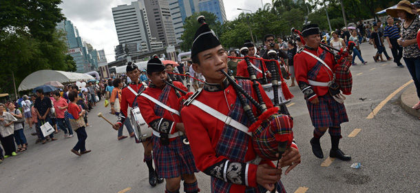 Members of a Thai police band play the bagpipes as they parade at an event organised by security forces to "return happiness to the people" at Lumpini park in Bangkok on June 15, 2014. With free meals, music concerts and health checks, Thailand's junta is waging a propaganda offensive to encourage "national happiness" following a military coup that has severely restricted civil liberties. AFP PHOTO / Christophe ARCHAMBAULT (Photo credit should read CHRISTOPHE ARCHAMBAULT/AFP/Getty Images)