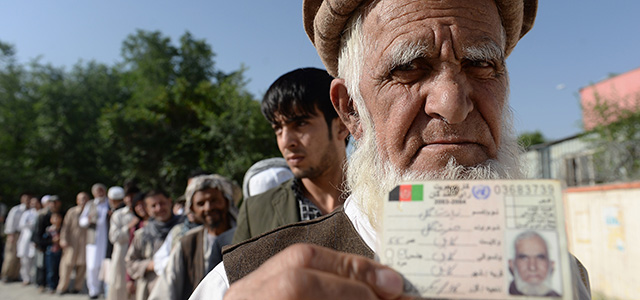 An Afghan resident wanting to vote poses for a photograph with his identity card as he waits for voting to start at a polling centre in Kabul on June 14, 2014. Afghans head to the polls on June 14 for a second-round election to choose a successor to President Hamid Karzai, with the threat of Taliban attacks and fraud looming over the country's first democratic transfer of power. AFP PHOTO/SHAH Marai (Photo credit should read SHAH MARAI/AFP/Getty Images)