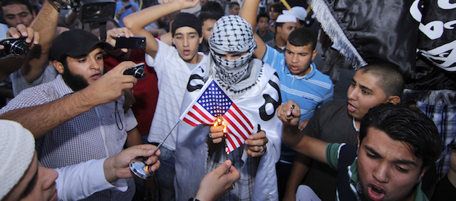 Dozens of supporters of the militant group, Ansar al-Shariah, burn an American flag and shout anti-American slogans denouncing the U.S. violation of Libya's sovereignty in the abduction of Abu Anas al-Libi, in the center of Benghazi, Libya, Monday, Oct. 7, 2013. On Saturday, Oct. 5, 2013, the U.S. Army's Delta Force captured Nazih Abdul-Hamed al-Ruqai, known by his alias Anas al-Libi, an al-Qaida leader linked to the 1998 American Embassy bombings in Kenya and Tanzania. (AP Photo/Mohammed el-Shaiky)