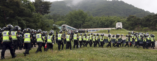 Police officers raid into a religious facility of the Evangelical Baptist Church in Anseong , South Korea, Wednesday, June 11, 2014. Thousands of South Korean police officers stormed a church compound Wednesday in their hunt for a fugitive billionaire businessman over April's ferry sinking that left more than 300 people dead or missing, officials said.(AP Photo/Yonhap, Shin Young-geun) KOREA OUT