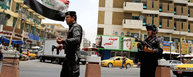 Iraqi federal policemen stand guard at a checkpoint in Baghdad, Iraq, Wednesday, June. 11, 2014. The Iraqi government has tightened its security measures after a stunning assault that exposed Iraq's eroding central authority, al-Qaida-inspired militants overran much of Mosul on Tuesday, seizing government buildings, pushing out security forces and capturing military vehicles as thousands of residents fled the Iraqi second-largest city. (AP Photo/ Karim Kadim)