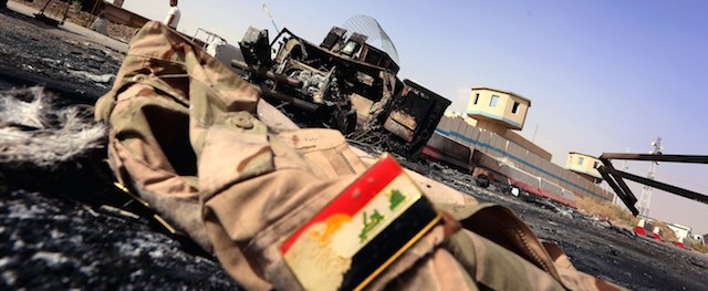 The jacket belonging to an Iraqi Army uniform lies on the ground in front of the remains of a burnt out Iraqi army vehicle close to the Kukjali Iraqi Army checkpoint, some 10km of east of the northern city of Mosul, on June 11, 2014, the day after Sunni militants, including fighters from the Islamic State of Iraq and the Levant (ISIL) overran the city. Half a million people were estimated to have fled Iraq's second largest city, as Islamist militants tightened their grip after overrunning it and a swathe of other territory, patrolling its streets and calling for government employees to return to work. AFP PHOTO/SAFIN HAMED (Photo credit should read SAFIN HAMED/AFP/Getty Images)