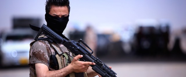 A masked Pershmerga fighter from Iraq's autonomous Kurdish region guards a temporary camp set up to shelter Iraqis fleeing violence in the northern Nineveh province, in Aski kalak, 40 kms west of the region's capital Arbil, on June 13, 2014. Thousands of people who fled Iraq's second city of Mosul after it was overrun by jihadists have been queuing in the blistering heat, hoping to enter the safety of the nearby Kurdish region and furious at Baghdad's failure to help them.
AFP PHOTO/SAFIN HAMED (Photo credit should read SAFIN HAMED/AFP/Getty Images)