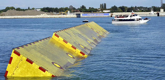 FILE - In this Saturday, Oct. 12, 2013 file photo, movable underwater panels emerge from the lagoon during the first official test of Venice movable barriers designed to prevent severe flooding in Venice, Italy. Italian authorities Wednesday, June 4, 2014 have arrested the mayor of Venice and 35 others in a sweeping corruption investigation related to the construction of underwater barriers to protect the historic city from flooding. Italian financial police confirmed Mayor Giorgio Orsoni's arrest Wednesday but had no further details. The arrests were the result of a three-year investigation by the financial police that led to the arrest last summer of the head of the consortium building the ambitious but long-delayed system of so-called Moses barriers. Authorities say 20 million euros ($27 million) was diverted abroad for the purpose of bribing politicians. (AP Photo/Luigi Costantini, Files)