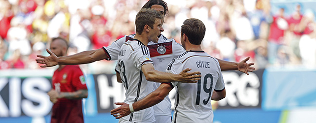 Germany's Thomas Mueller, left, celebrates after scoring the opening goal during the group G World Cup soccer match between Germany and Portugal at the Arena Fonte Nova in Salvador, Brazil, Monday, June 16, 2014. (AP Photo/Matthias Schrader)
