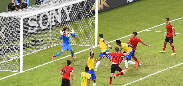 Mexico's goalkeeper Guillermo Ochoa (L) punches the ball during a Group A football match between Brazil and Mexico in the Castelao Stadium in Fortaleza during the 2014 FIFA World Cup on June 17, 2014. AFP PHOTO / FABRICE COFFRINI