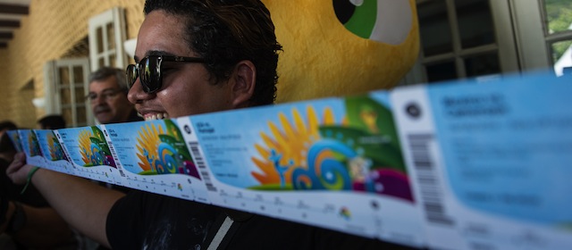 Football fan Vanderrson Balbino shows the eight tickets he bought for the upcoming FIFA World Cup Brazil 2014 as the designated ticketing pick-up centres opened in 12 host cities on April 18, 2014, at Botafogo's club in Rio de Janeiro, Brazil. AFP PHOTO / YASUYOSHI CHIBA (Photo credit should read YASUYOSHI CHIBA/AFP/Getty Images)