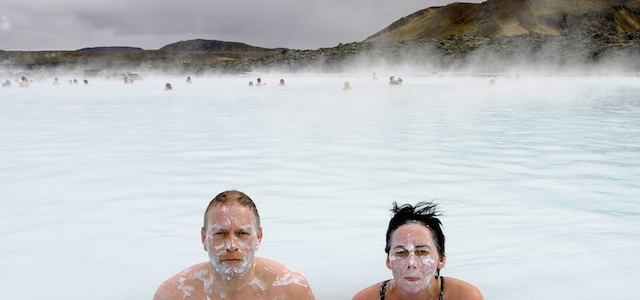 Tourists stand in the Blue Lagoon outside Reykjavik on 26 April, 2009. The Blue Lagoon's blue and green waters come from natural hot water springs flowing through rocks of lava. The lagoon might have some health properties. AFP PHOTO OLIVIER MORIN. (Photo credit should read OLIVIER MORIN/AFP/Getty Images)