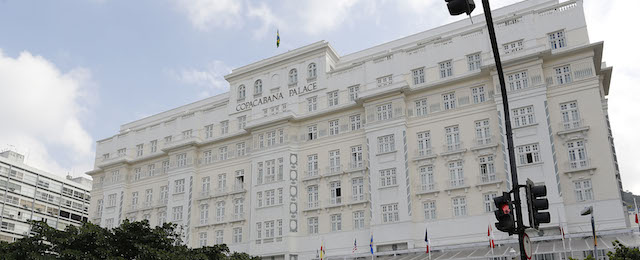 Pedestrians cross a street in front of the Copacabana Palace where Ray Whelan, of MATCH Services, is staying, in Rio de Janeiro, Brazil, Tuesday, July 8, 2014. The World Cup corporate hospitality executive was arrested at the Copacabana Palace Monday, the hotel used by FIFA officials during the World Cup. Whelan, who is suspected of involvement with a ticket-scalping ring, was released from prison early Tuesday. (AP Photo/Leo Correa)