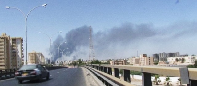 In this image made from video by The Associated Press, smoke rises from the direction of Tripoli airport in Tripoli, Libya, Sunday, July 13, 2014. Rival militias battled Sunday for the control of the international airport in Libya's capital, as gunfire and explosions echoed through the city and airlines canceled some international flights. (AP Photo)