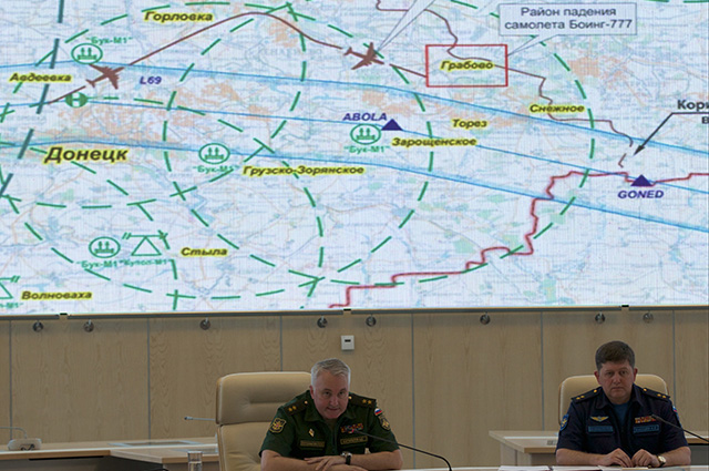 Lieutenant-General Andrey Kartopolov, head of main operational department of Russian military's General Staff, center, speaks to the media during a news conference in Moscow, Monday, July 21, 2014. Russian officials offered evidence Monday, showing photos they said proved that Ukrainian surface-to-air systems were operating in the area in the days before the crash. Russian officials also offered evidence that a Ukrainian Sukhoi Su-25 fighter jet had flown “between 3 to 5 kilometers (2 to 3 miles)” from the Malaysia Airlines jet. Screen demonstrates the scheme of air traffic over Donetsk, Malaysia Airlines jet route and place of it's crash, red box, as well as Ukrainian antiaircraft missile launchers positions. At right is Igor Makushev, chief of Russia's Air Force general staff. (AP Photo/Ivan Sekrtarev)