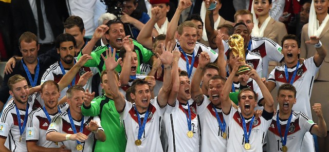 Germany's defender and captain Philipp Lahm (front 2R) holds up the World Cup trophy as he celebrates on with his teammates after winning the 2014 FIFA World Cup final football match between Germany and Argentina 1-0 following extra-time at the Maracana Stadium in Rio de Janeiro, Brazil, on July 13, 2014. AFP PHOTO / PEDRO UGARTE