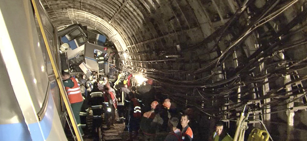 CAPTION CORRECTION REMOVES REFERENCE TO CAUSE OF DERAILMENT In this frame grab provided by the Russian Ministry for Emergency Situations shows frame grab from a video showing rescue teams working inside the tunnel where several cars of the wrecked train look almost coiled, occupying the entire space of the tunnel of Moscow subway in Moscow, Russia, on Tuesday, July 15, 2014. Workers were seen trying to force open the mangled doors of the car where dead bodies are supposed to be. A rush-hour subway train derailed in Moscow Tuesday, killing more than 20 people and injuring scores, emergency officials said. The cause of the derailment is being investigated. (AP Photo/Russian Emergency Situation Ministry)