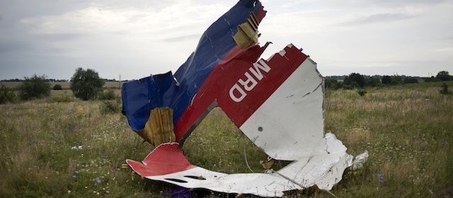 A piece of the crashed Malaysia Airlines Flight 17 lies in the grass near the village of Hrabove, eastern Ukraine, Saturday, July 19, 2014. World leaders demanded Friday that pro-Russia rebels who control the eastern Ukraine crash site of Malaysia Airlines Flight 17 give immediate, unfettered access to independent investigators to determine who shot down the plane. (AP Photo/Evgeniy Maloletka)