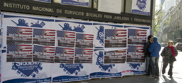 Posters on a wall against the "vulture funds" in Buenos Aires on June 18, 2014. The US Supreme Court Monday rejected Argentina's appeals against paying at least $1.3 billion to hedge fund investors in its defaulted bonds, piling pressure on the country's finances. Economy Minister Axel Kicillof warned Tuesday that if Argentina implements a new US court ruling against Buenos Aires, it would push the South American nation into default. The posters read "Enough Vultures - Argentine united in a national cause" AFP PHOTO/ALEJANDRO PAGNI (Photo credit should read ALEJANDRO PAGNI/AFP/Getty Images)