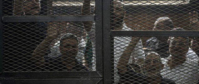 Egyptian Muslim Brotherhood leader Mohamed Badie (2nd R) and other defendants gesture during their trial in the capital Cairo on June 7, 2014. The court postponed to July 5 the verdict in the trial of Muslim Brotherhood leader Mohamed Badie and 37 others for inciting violence that killed two people last summer. But it sentenced to death 10 defendants who are on the run, and a final ruling on their cases is expected the same day once they are reviewed. AFP PHOTO /KHALED DESOUKI (Photo credit should read KHALED DESOUKI/AFP/Getty Images)