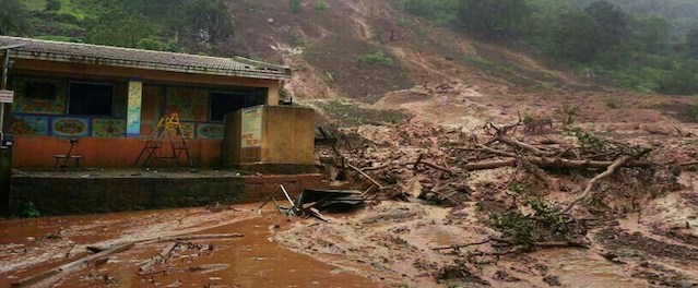 A mudslide surrounds a building in Malin village in Pune district the western Indian state of Maharashtra on July 30, 2014. A major landslide struck a village in western India following heavy monsoon rains, leaving 150 people feared trapped, a rescue official said. The landslide submerged Malin village in Pune district of Maharashtra state, said Alok Avasthy, regional commandant at the National Disaster Response Force. "Civil authorities say around 42 to 50 houses are affected. 150 people are feared trapped. We have sent two teams," Avasthy told AFP. AFP PHOTO/STR (Photo credit should read STR/AFP/Getty Images)