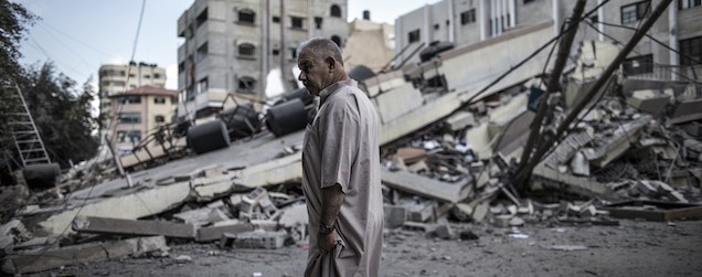 Un uomo palestinese di fronte a un edificio distrutto dagli attacchi aerei israeliani.
(MARCO LONGARI/AFP/Getty Images)