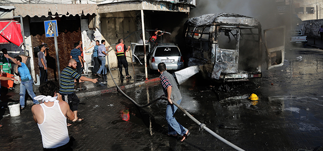 Firefighters hose a van after two people were killed in it in an Israeli airstrike in Gaza City on Thursday, July 31, 2014. Israel said Thursday it has called up another 16,000 reservists, allowing it to potentially widen its Gaza operation against the territory's Hamas rulers in a three-week-old war that has killed more than 1,300 Palestinians and more than 50 Israelis. (AP Photo/Adel Hana)