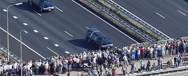 Una folla assiste al passaggio del corteo con le bare nel tragitto da Eindhoven a Hilversum (AFP PHOTO / ANP /JERRY LAMPEN)