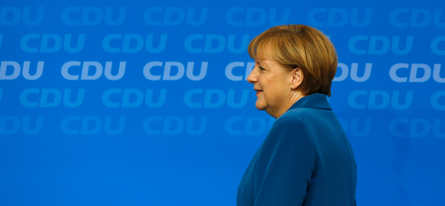 German Chancellor Angela Merkel walks onto the stage passing a sign reading "For Germany" prior to addressing supporters after preliminary election results were announced at the party headquarters in Berlin, Germany, Sunday, Sept. 22, 2013. An exit poll indicates that Merkel's conservatives have emerged by far the strongest force in Germany's election, though it's unclear whether her coalition partners will stay in parliament. (AP Photo/Michael Sohn)