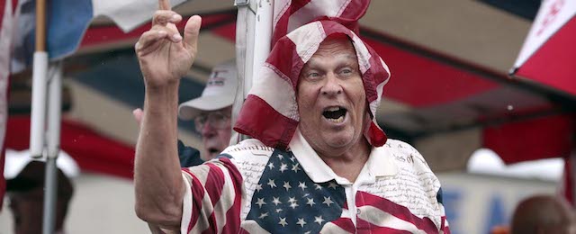 The Berkshire Hillsmen, draped in flags, sing, on their float during the rainy Fourth of July parade in downtown Pittsfield, Ma., Friday, July 4, 2014. (AP Photo/Stephanie Zollshan, The Berkshire Eagle)