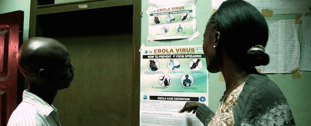 Liberian people read an information sign about Ebola set on a wall of a public health center on July 31, 2014 in Monrovia. Liberia announced on July 30 it was shutting all schools and placing "non-essential" government workers on 30 days' leave in a bid to halt the spread of the deadly Ebola epidemic raging in west Africa. The impoverished country, along with neighbouring Guinea and Sierra Leone, is struggling to contain an epidemic that has infected 1,200 people and left 672 dead across the region since the start of the year. AFP PHOTO / STRINGER (Photo credit should read STRINGER/AFP/Getty Images)