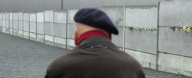 BERLIN - NOVEMBER 9: An elderly man looks at an original portion of the Berlin Wall at a monument November 9, 2004 in Berlin, Germany, on the 15th anniversary of the demolition of the Wall. The Berlin Wall, built in 1961 under orders from former Soviet leader Nikita Khruschev, was meant to prevent East Germans from fleeing the communist East half of the city to the capitalist West. (Photo by Sean Gallup/Getty Images)