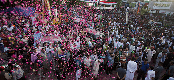 People shower rose petals over supporters of Pakistan's fiery anti-government cleric Tahir-ul-Qadri at a rally in Islamabad, Pakistan, Sunday, Aug. 17, 2014. Pakistan's cricketer-turned-politician Imran Khan and Qadri led massive rallies in Pakistan’s capital, demanding Prime Minister Nawaz Sharif step down over alleged fraud in last year’s election in front of thousands of protesters. (AP Photo/B.K. Bangash)