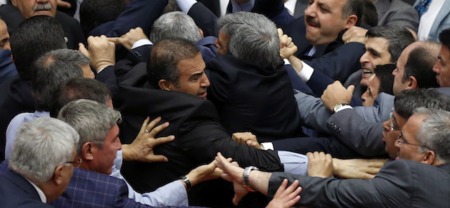 Legislators from Prime Minister Recep Tayyip Erdogan's party and the opposition Nationalist Action Party brawl at the parliament during a debate on whether parliament should open an inquiry into Islamic militants joining the fighting in Iraq and Syria, using Turkey’s territory, in Ankara, Turkey, Monday, Aug. 4, 2014. The fist-fight injured three legislators and forced the speaker to adjourn debate for the day.(AP Photo)