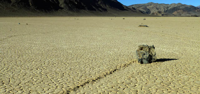 This undated photo provided by the National Park Service shows rocks that have moved across a dry lake bed in Death Valley National Park in California's Mojave Desert. For years scientists have theorized about how the large rocks — some weighing hundreds of pounds — zigzag across Racetrack Playa leaving long trails etched in the earth. Now two researchers at the Scripps Institution of Oceanography have photographed these "sailing rocks" being blown by light winds across the former lake bed. Cousins Richard Norris and James Norris say the movement is made possible when ice sheets that form after rare overnight rains melt in the rising sun, making the hard ground muddy and slick. (AP Photo/National Park Service)