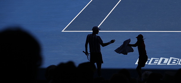 Tomas Berdych of the Czech Republic is silhouetted as he gets a towel form a ball boy during his quarterfinal against David Ferrer of Spain at the Australian Open tennis championship in Melbourne, Australia, Tuesday, Jan. 21, 2014. (AP Photo/Aijaz Rahi)