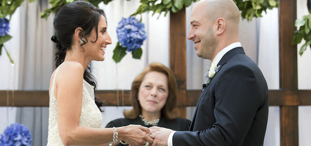 In this photo taken on Saturday, Aug. 23, 2014, and released by Hyatt Regency Boston, Boston Marathon bombing survivor, James Costello, right, marries Krista D’Agostino at the hotel in Boston. Officiating is Carol Merletti, center. The couple met at Spaulding Rehabilitation Hospital where D’Agostino worked as a nurse and helped Costello recover from his burns and injuries. (AP Photo/Prudente Photography)